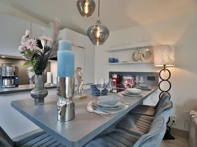 Nautic Lounge – Beach Garden: Design-Tresen mit stilvoll gedecktem Tisch und moderner Küche in Haffkrug.