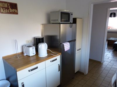 Die Küche mit Kühlschrank und weiteren Utensilien