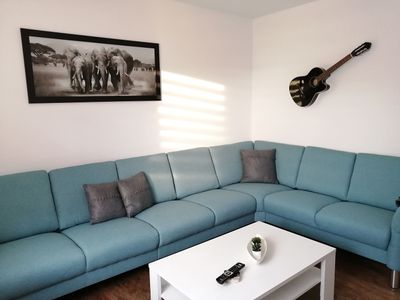 Wohnzimmer mit goßem Sofa im Ferienhaus Schlüter