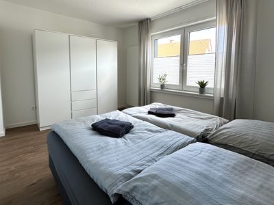 Schönes Schlafzimmer mit Kleiderschrank und großen Fenstern