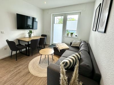 gemütliches Sofa mit Fernseher und Esstisch im kuscheligen Wohnbereich
