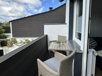 schöne Terrasse mit gemütlichen Stühlen und einem kleinen Holztisch