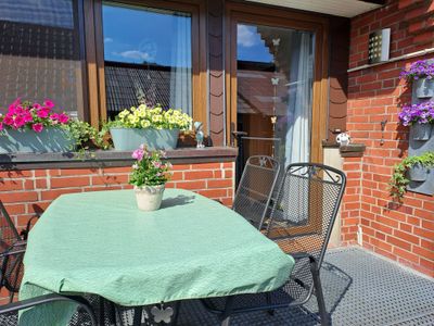 Sonnige Terrasse mit Sitzgelegenheiten am Tisch