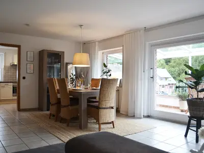 Heller und lichtdurchfluteter Wohnbereich mit Blick auf die Loggia und die umliegenden Wälder.