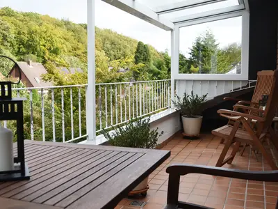 Große überdachte Loggia mit Blick in den Garten und auf den Wald.
