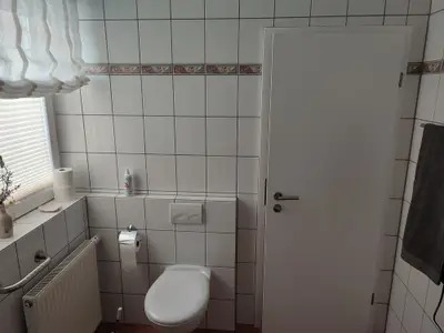 Badezimmer mit Dusche, Waschbecken und Schminkspiegel