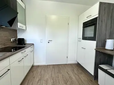 moderne, abgetrennte Küche mit Wasserkocher, Kaffeemaschine und Backofen