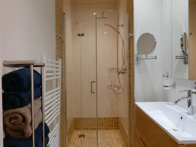 Das Badezimmer mit großem Waschbecken und ebenerdiger Dusche