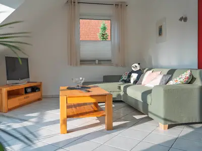 Der helle und moderne Wohnbereich mit Couch und TV
