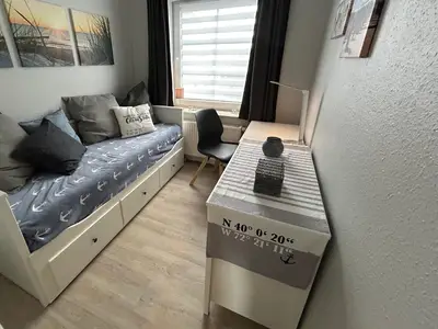 zweites Schlafzimmer mit Schrank, Kommode und kleinem Schreibtisch