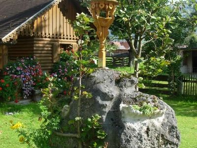 Miniglockenturm mit Gartenhaus im Hintergrund