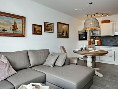 Wohnzimmer mit Sofaecke und Küchenzeile