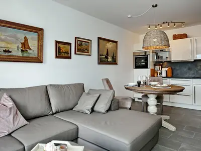 Wohnzimmer mit Sofaecke und Küchenzeile