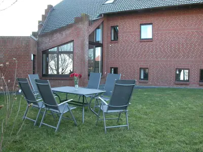 Gartenecke mit Ampelschirn und mit Blick auf den Wintergarten