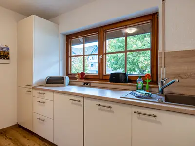 Separate Küche mit Backofen, Geschirrspülmaschine, Kühlschrank, Mikrowelle, Geschirr und Küchenzubehör