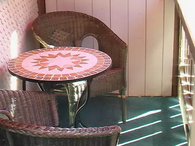 Balkon: Tisch mit Korbstühlen