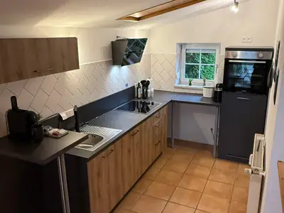Voll ausgestattete Küche mit Herd, Ofen, Kühlschrank und Spülmaschine