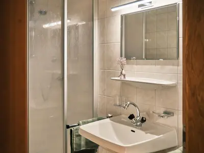 Bad mit Dusche, Waschbecken und Spiegel