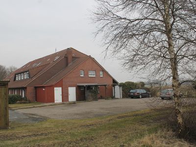 Außenansicht des Gebäudes. Hauseingang mit großem Parkplatz