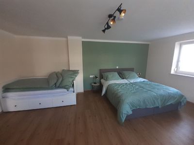 Großes Schlafzimmer mit Doppelbett und Einzelbett