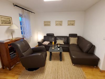 Wohnzimmer mit Ledercouch und Sessel