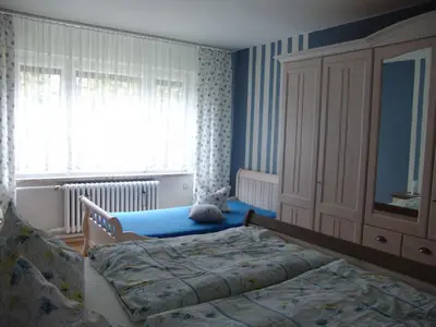 An der Wand gegenüber stehtt ein geräumiger Schrank sowie ein Single-Bett für 1 Aufbettung.