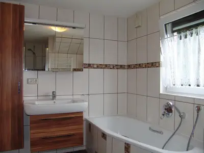 Im modernen Badezimmer befindet sich eine Wanne für ein entspannendes Wohlfühlbad.