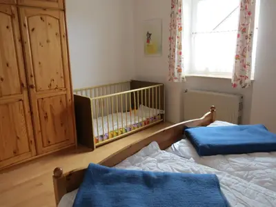 Schlafzimmer mit Doppelbett und Kinderbett
