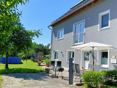 Sonnige Terrasse mit Garten und Parkplatz