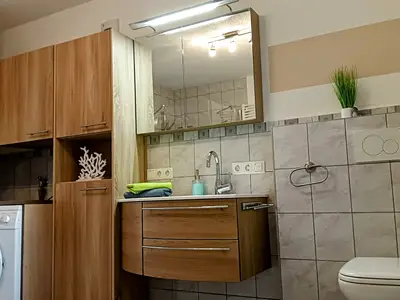 Badezimmer mit Dusche, Badewanne und Waschmaschine