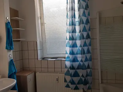 Badezimmer mit Badewanne und Dusche