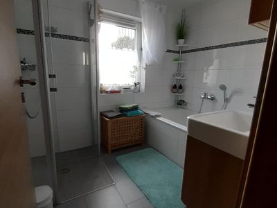 Bad/Dusche. mit ebenerdiger Dusche, großer Badewanne, Waschbecken und Spiegelschrank