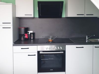 Küche mit Küchenzeile (Herd, Backofen, Spülmaschine) und Essplatz