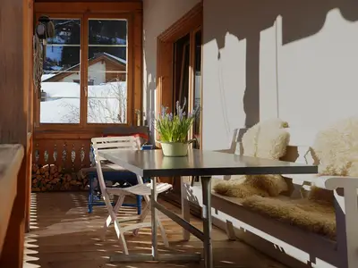 Südbalkon mit Esstisch, Bank und Stühlen / Liegestuhl und Liege mit Fussbank