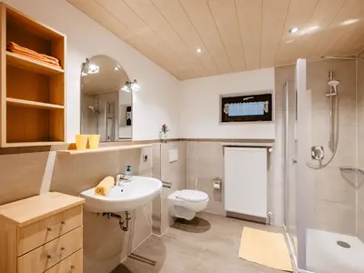 Badezimmer mit Dusche, WC, Handtücher und Föhn