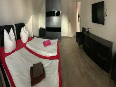 Schlafzimmer mit Kommode, Schrank, Safe und Fernseher