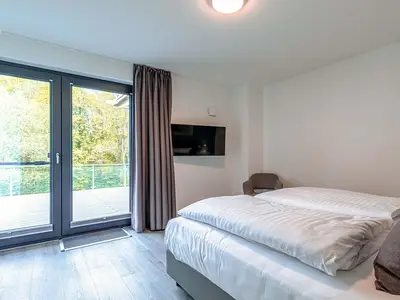 Apartment K15 Tao-Suite Krakow – helles, komfortables Schlafzimmer mit bodentiefen Fenstern und Zugang zur Terrasse