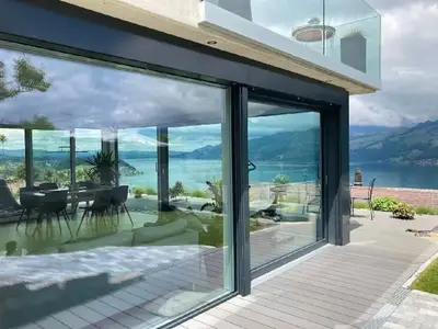 Wunderschöne Aussicht mit grosser Glasfront auf Berge und Thunersee