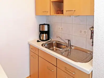 Kochbereich. Spüle mit Kaffeemaschine, Toaster, Wasserkocher, Geschirr
