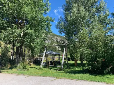 Gästegarten im Sommer mit Schaukel und Pavillon