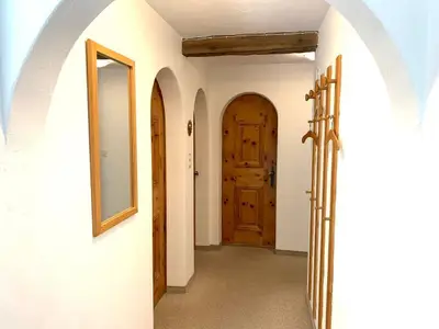 Flur mit Wandspiegel, Garderobe, Einbauschrank um die Ecke
