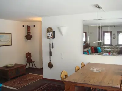 Blick ins Wohnzimmer mit Esstisch und Gang zu den Schlafzimmern.