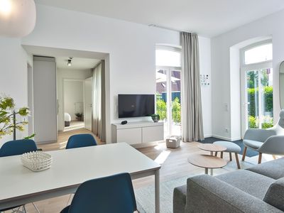 Wohn-Essbereich mit Couch, Sessel und Flatscreen TV