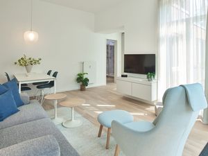 Wohn-Essbereich mit Couch, Sessel und Flatscreen TV
