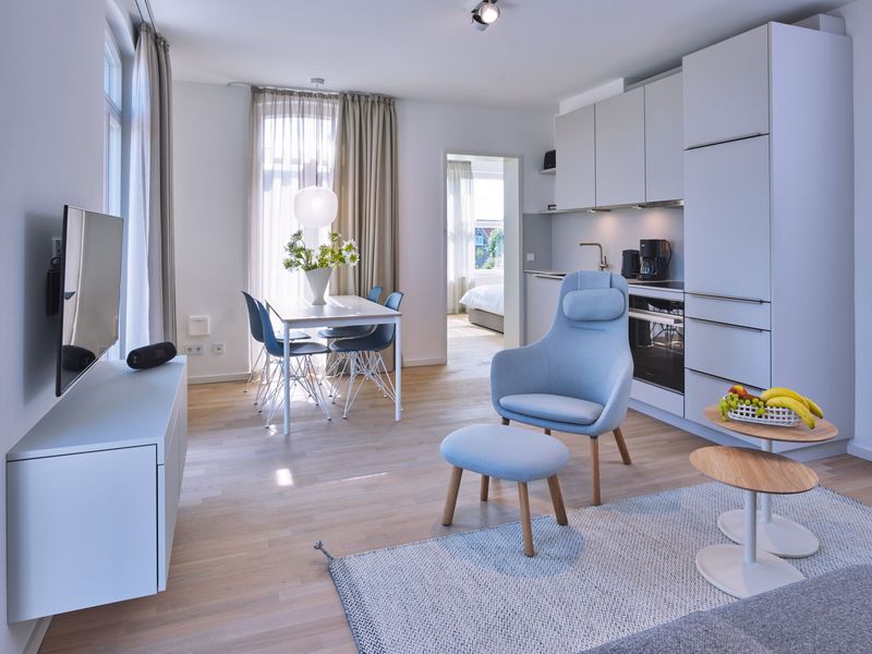 Wohn-Essbereich mit Couch, Esstisch, Sitzgelegenheit und Küchenzeile