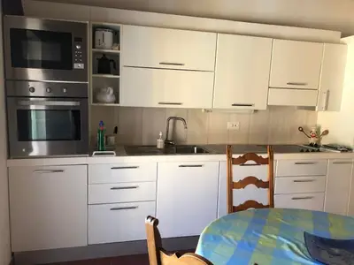 Küche mit Mikrowelle, Ofen, Teller, Gläsern und Pfannen.