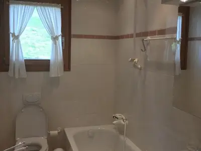 Badezimmer mit Badewanne (ohne Vorhang) und Doppellavabo