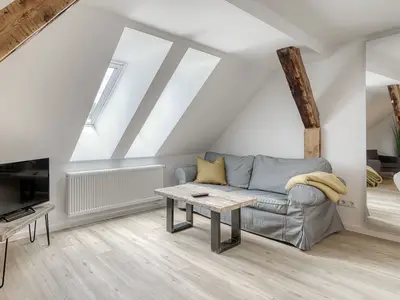 Ferienwohnung City Suite Couch und TV im Wohnzimmer