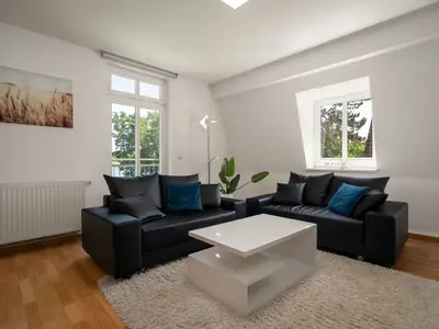 Apartment Strandglück Malchow - Wohnzimmer mit schwarzem Sofa