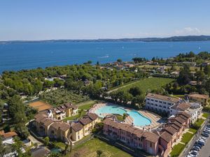 Drohnenfoto des Wohnhauses mit Schwimmbad mit dem See im Hintergrund